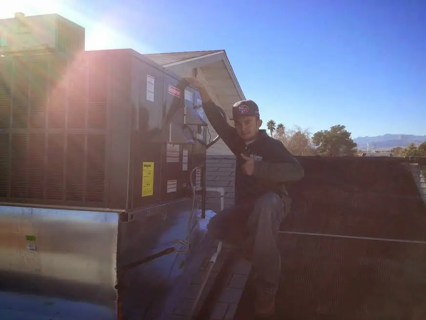 HVAC technician performing Heat Pump Repair on a rooftop unit in Gleneagle